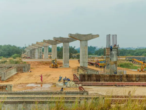 Bridge piers under construction, with machinery and workers on site