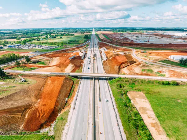 Aerial view of a highway being widened, with earthwork on both sides